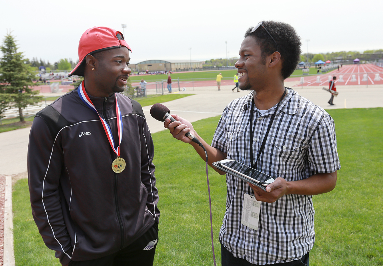 Moore, right, interviews track-and-field athlete Robert Starnes outside Foster Track on May 7, 2016.