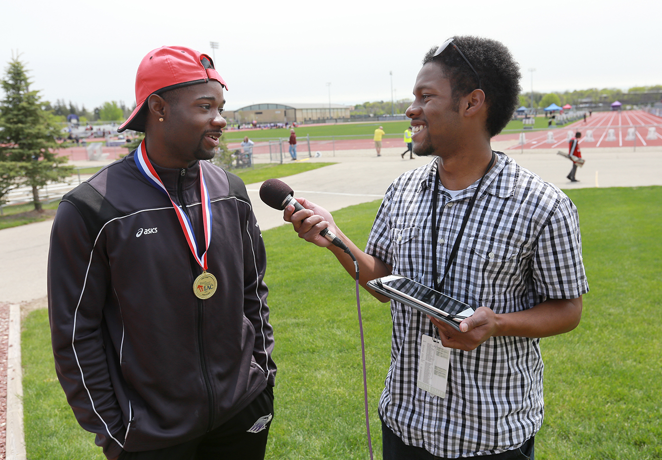 Connor Moore Moore, right, interviews track-and-field athlete Robert Starnes outside Foster Track on May 7, 2016.