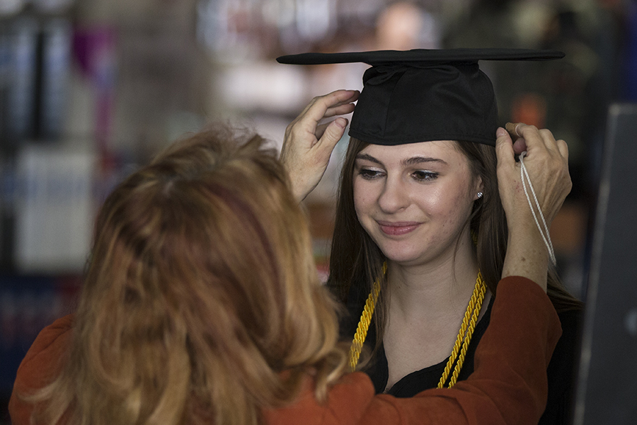 Student being fitted for graduation cap.