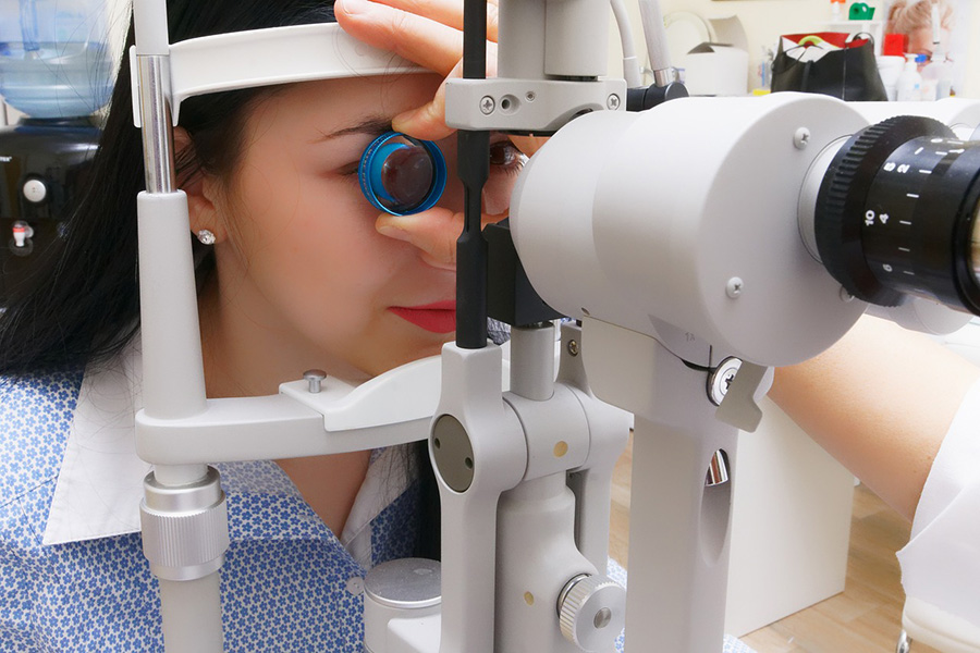 A person gets their eyes checked with an ophthalmoscope.