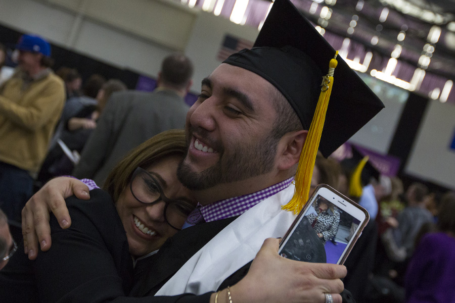 A student hugs their mom at graduation.