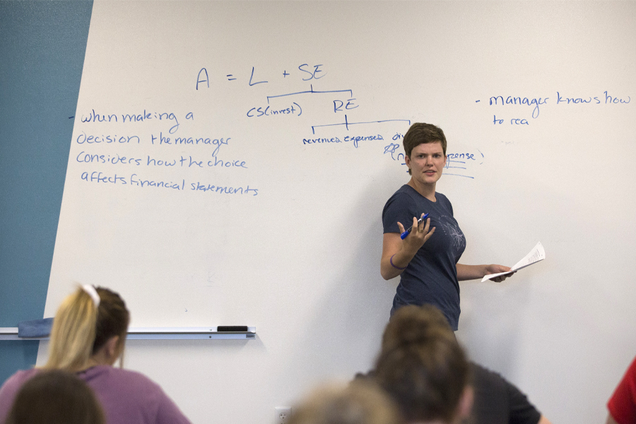 A faculty member teaches at a whiteboard.