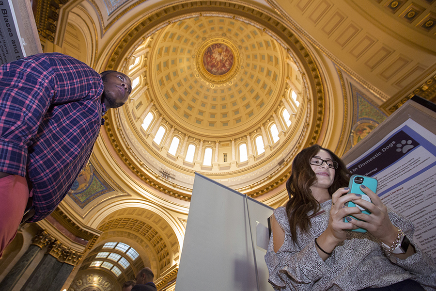 Two students stand in the Rotunda of the Wisconsin State Capitol building.