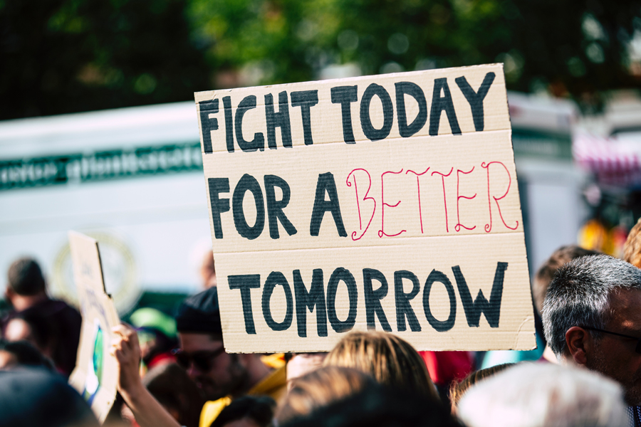 A person holds a sign that says Fight For a Better Tomorrow.