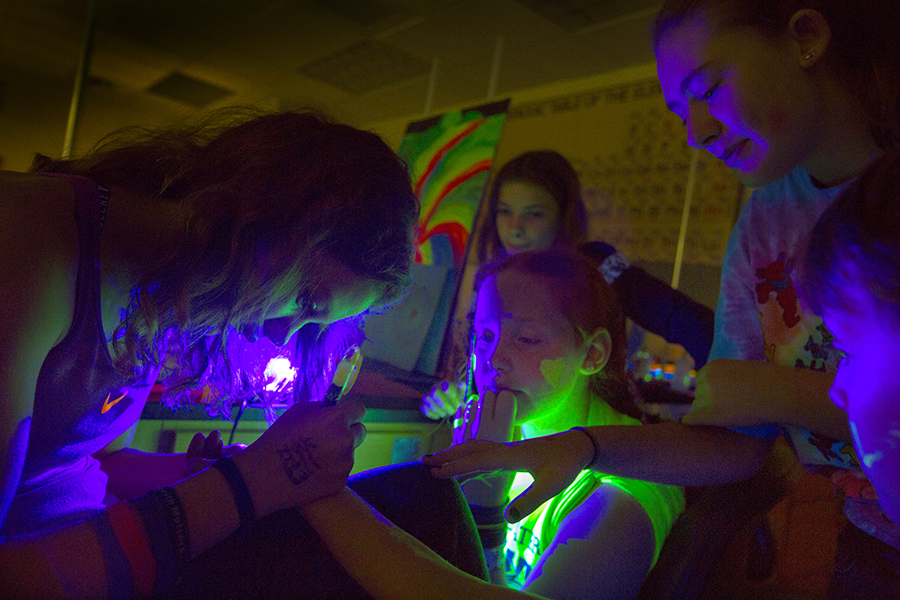 Students use different inks under a black light.