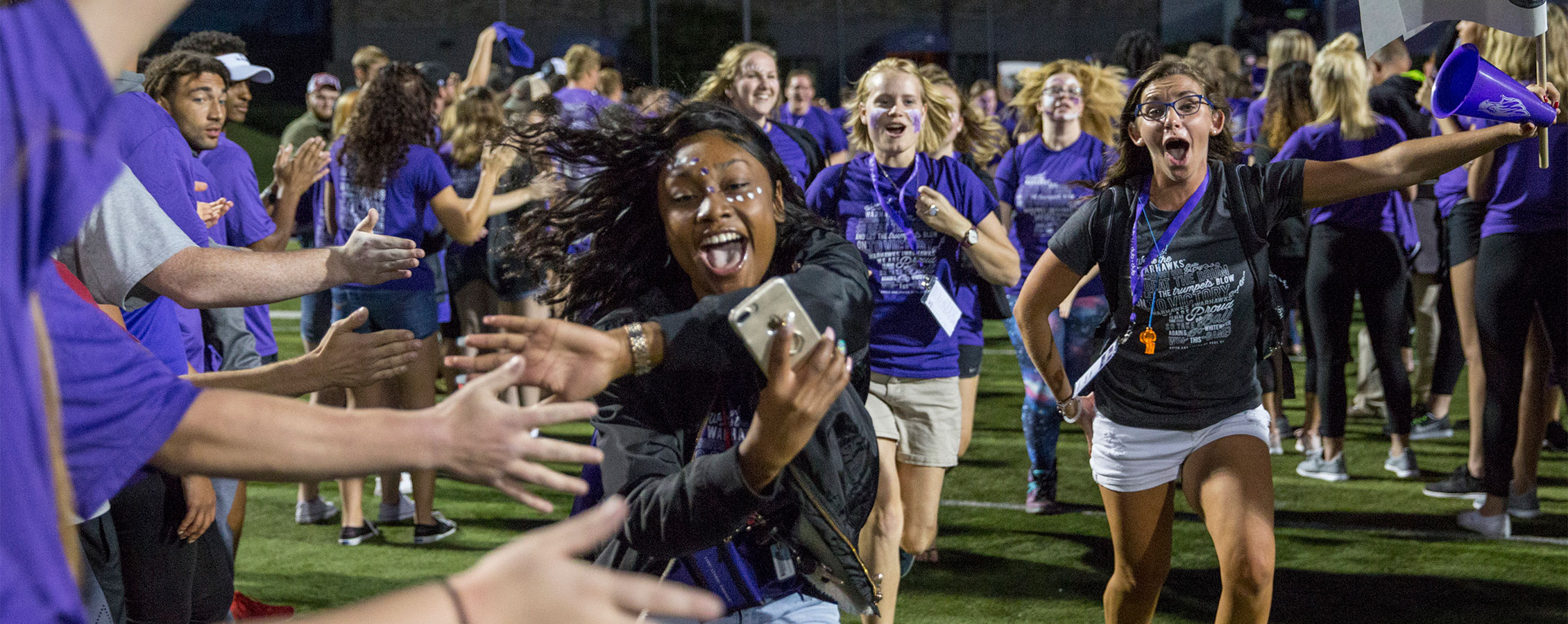  First-year students (freshman) & their peer mentors run through a human welcome tunnel of students & staff.