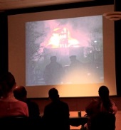 photo of people at the Old Main Lane reception watching video of Old Main fire 