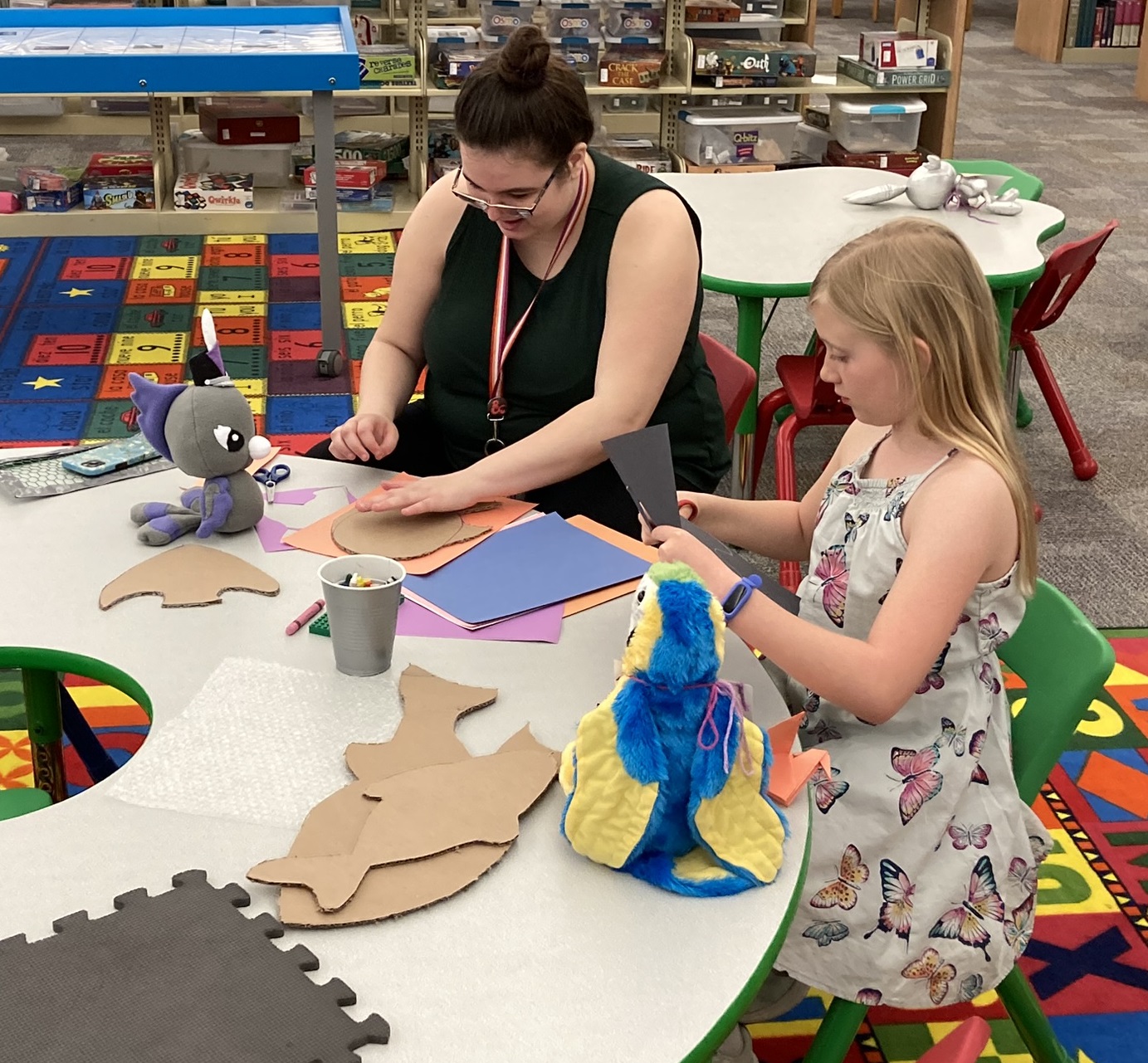 Student volunteers and children working on a craft at a table