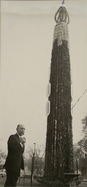 Photo of President Carter standing in fron tof large birthday candle.