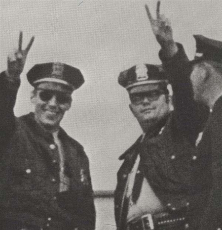 Police Officers holding up peace signs at the anti-war march