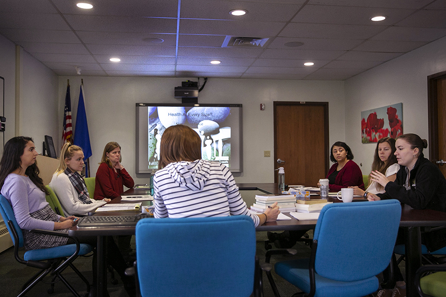 Graduate and doctoral interns and professional staff share experiences around a table.