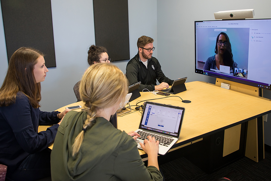 Students gathered around large monitor