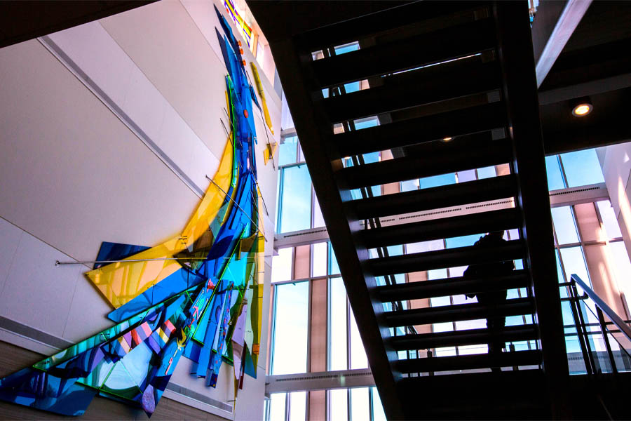 The lobby of Hyland Hall showing a staircase and bright blue and yellow artwork.
