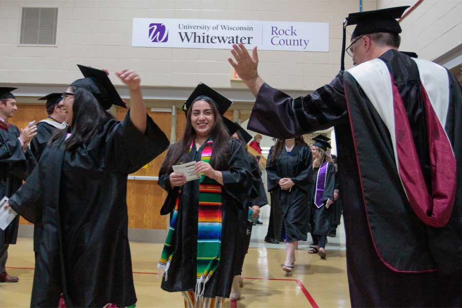 Students at commencement are cheered on by faculty.