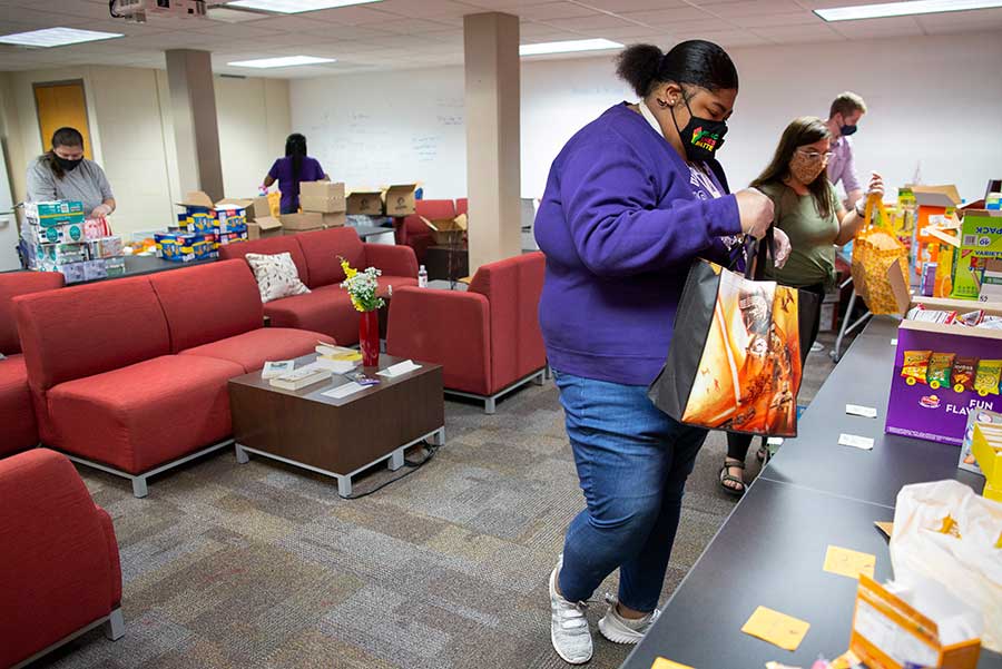 Aaliya Evans gathers nonperishable food and other items to put into care bags for students.