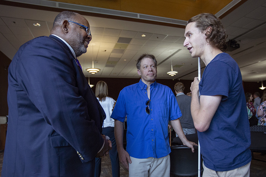 A student with a visual impairment speaks with Chancellor Watson.