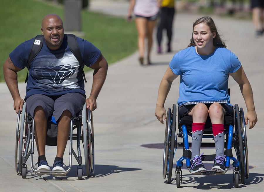 Two students in wheelchairs have a conversation as they cross the mall on the UW-Whitewater campus.