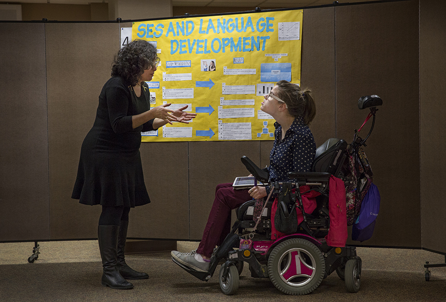 A student in a wheelchair speaks with a faculty member.