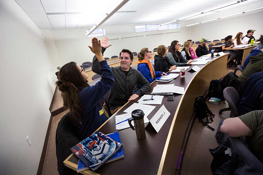 Two students high-five while in class.