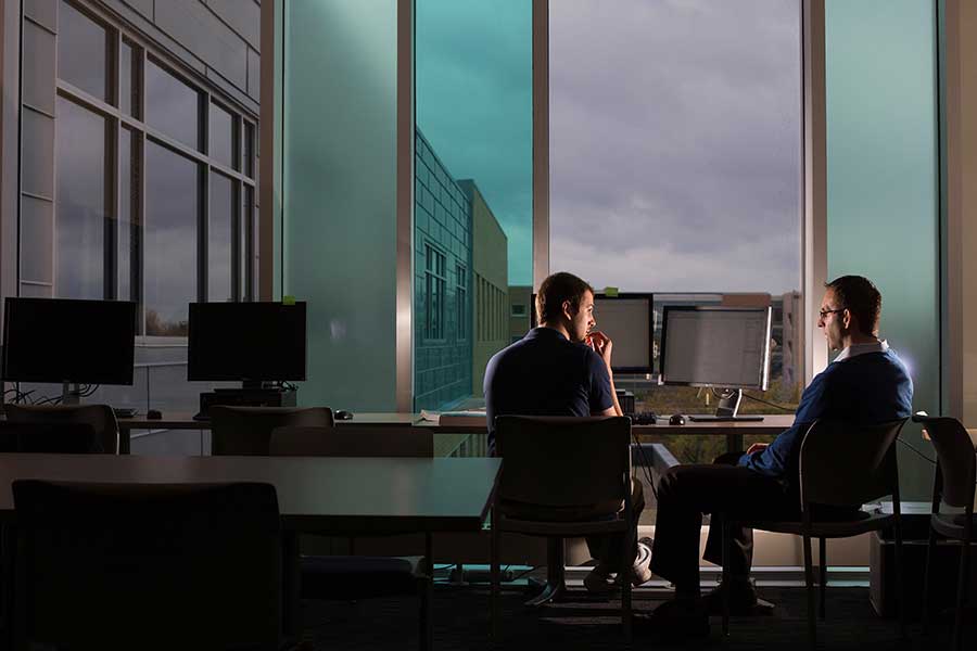 David Welsch sits with a UW-Whitewater student by the large windows in Hyland Hall.