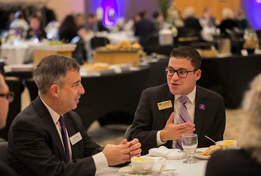 Brian Martinez, Warhawk alum, speaks with UW System Vice President for Finance Sean Nelson in the Hamilton Room of the University Center.