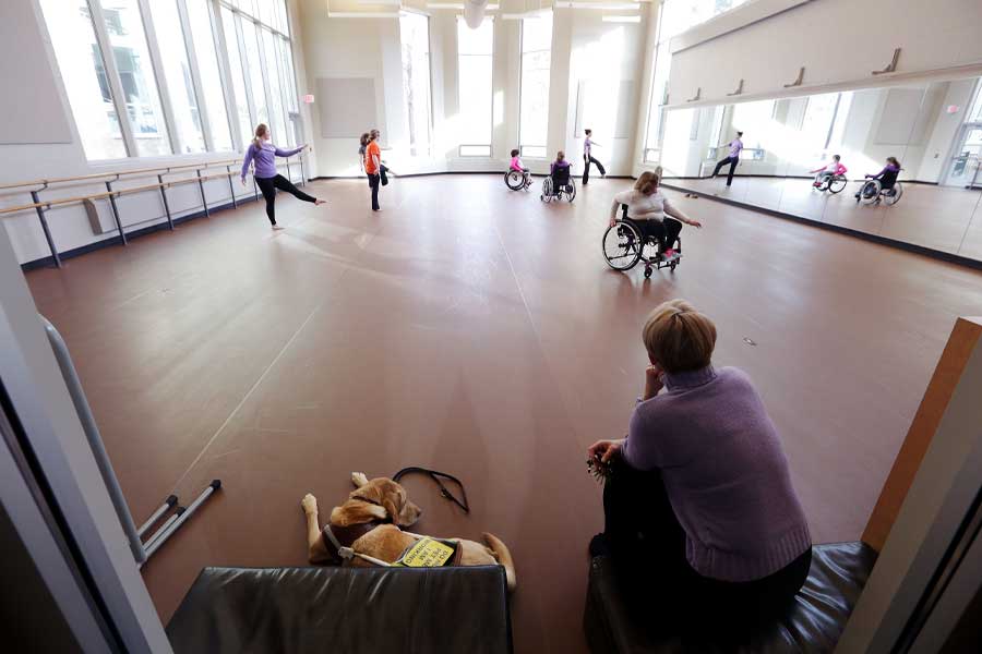 Professor Barb Grubel in a dance studio with several students.