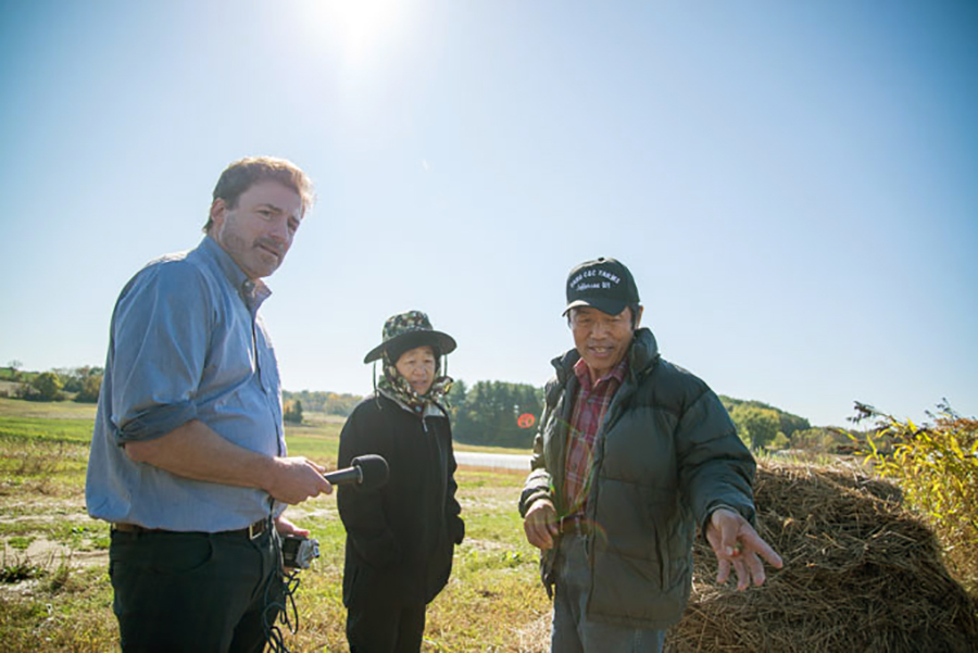 James Levy in a field with two people.