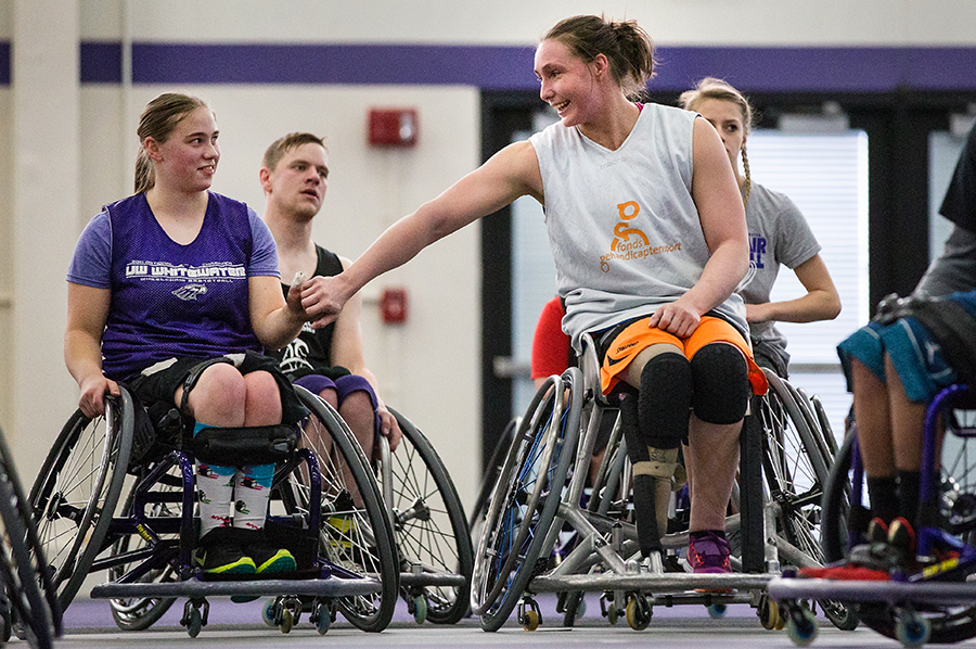 Lindsey Zurbrugg and Mariska Beijer exchange a fist bump on the basketball court.