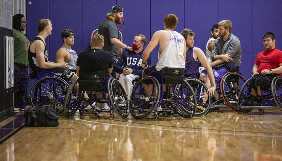 A group of people in the wheelchair basketball gym.