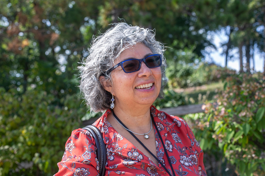 Pilar Melero stands outside with trees in the background.