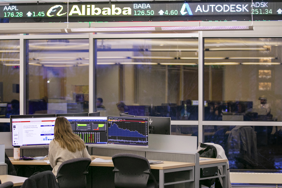 Courtney Jentz sits at a desk with back to camera in the trading room in Hyland Hall.