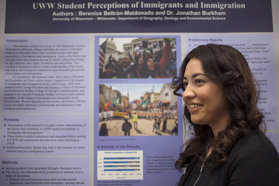 Una estudiante frente a su póster de investigación de pregrado.