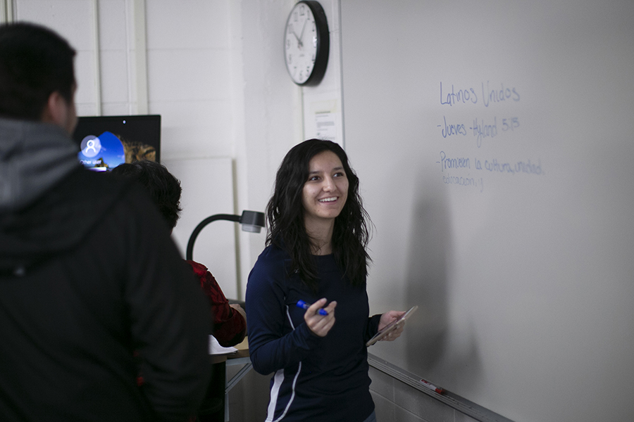 una estudiante escribe en español en una pizarra.