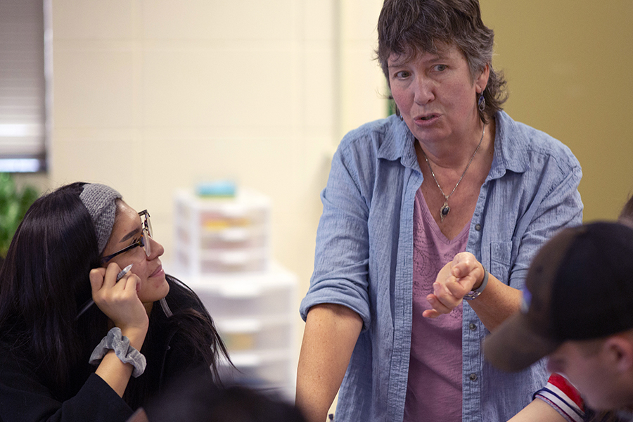 las estudiantes escuchan mientras habla una profesora.