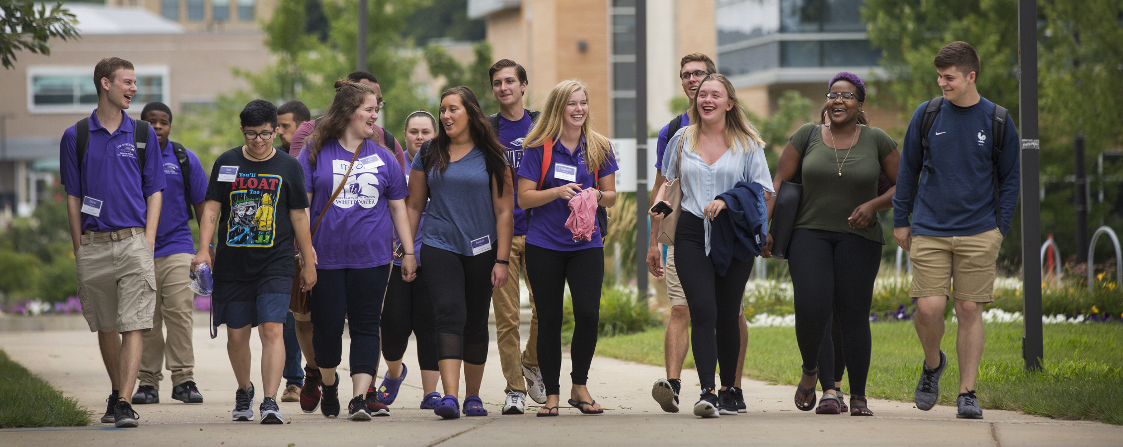 A group of students walk together outdoors on the UW-Whitewater campus.