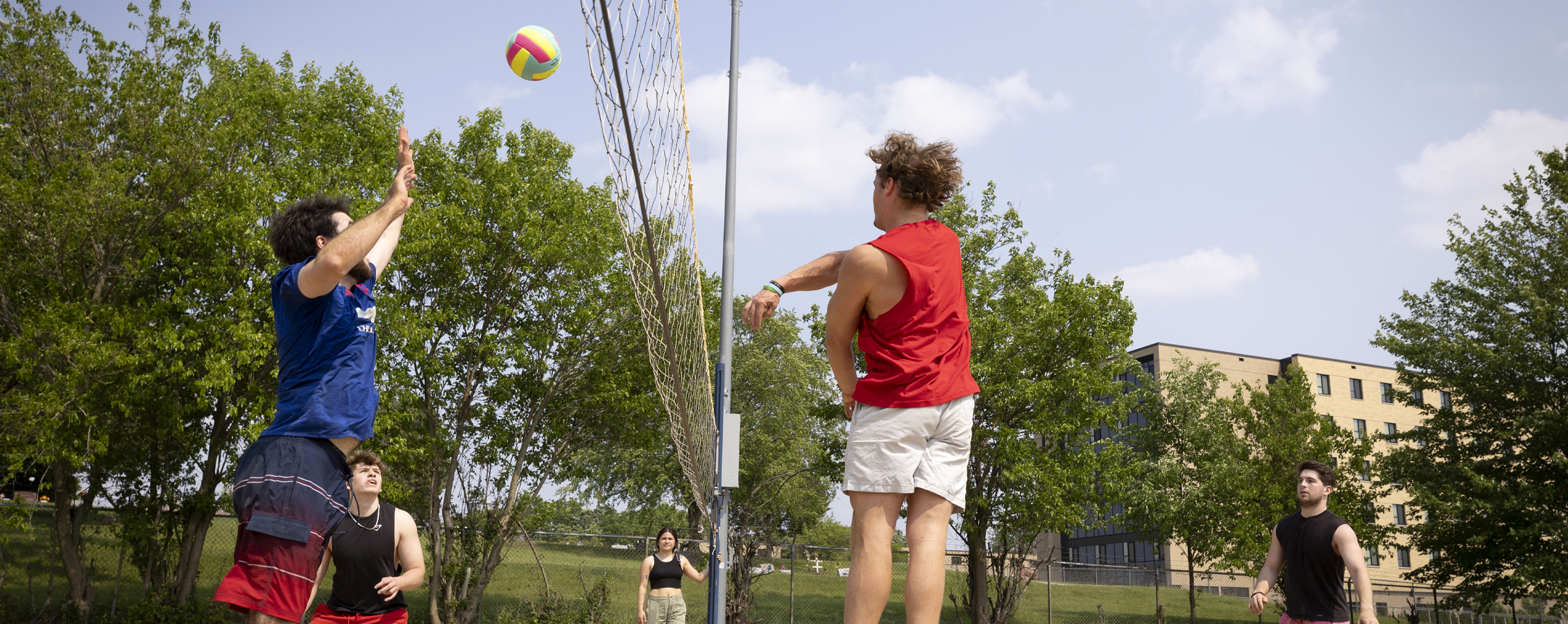 Students playing volleyball outside of the residence halls.
