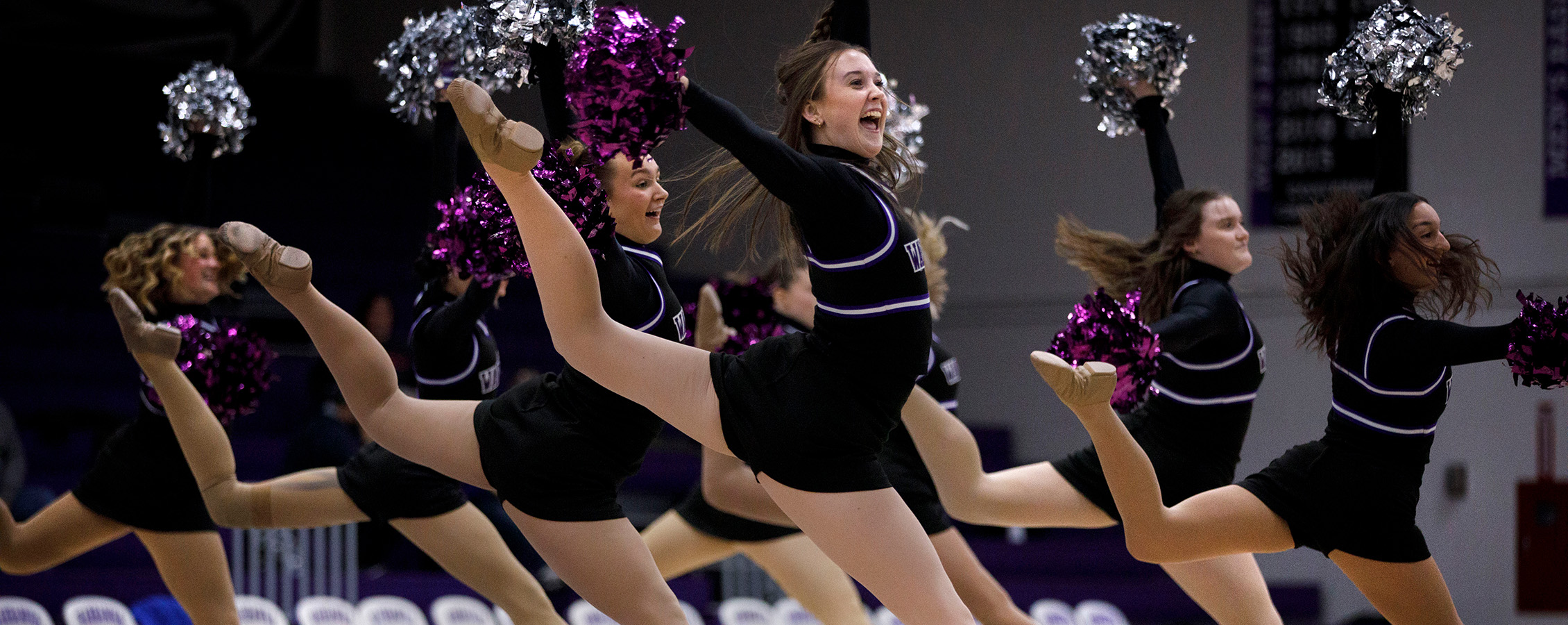Members of the UW-Whitewater Dance Team jump in the air while performing