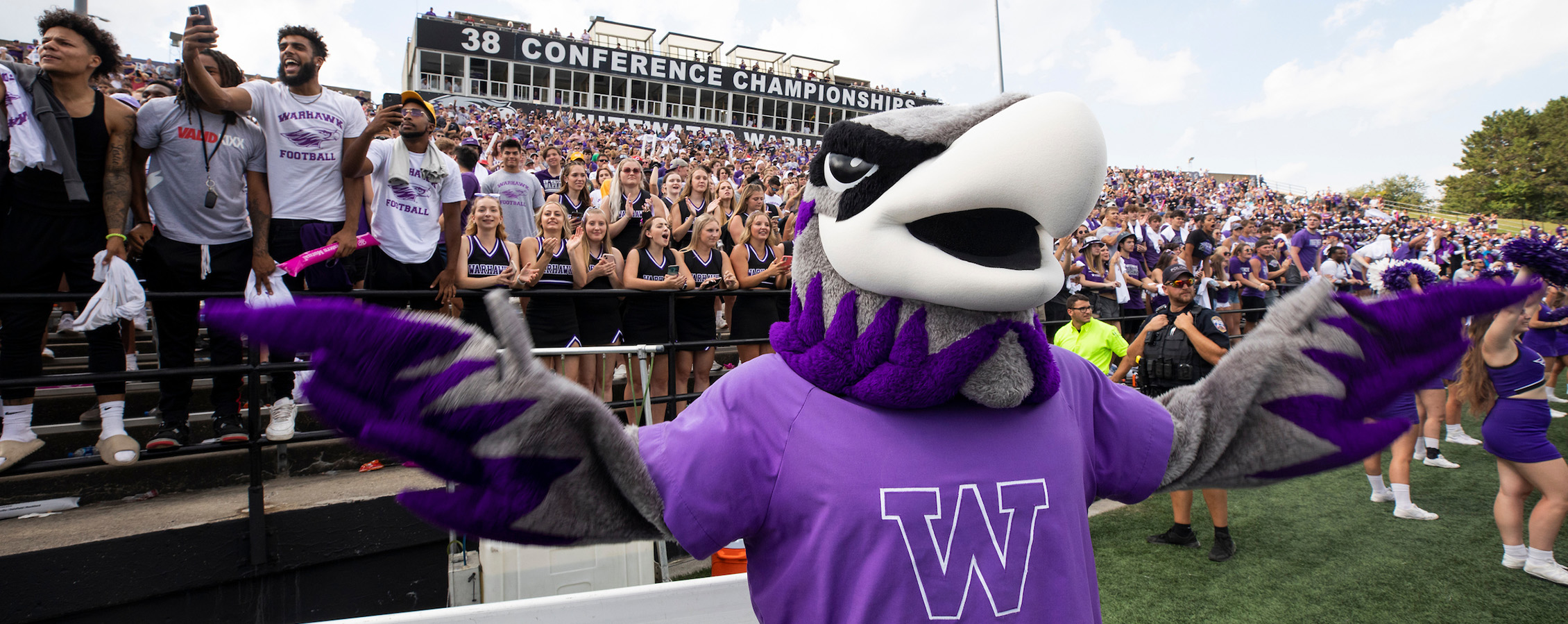 Willie Warhawk spreads his wings in front of a crowd at a football game.