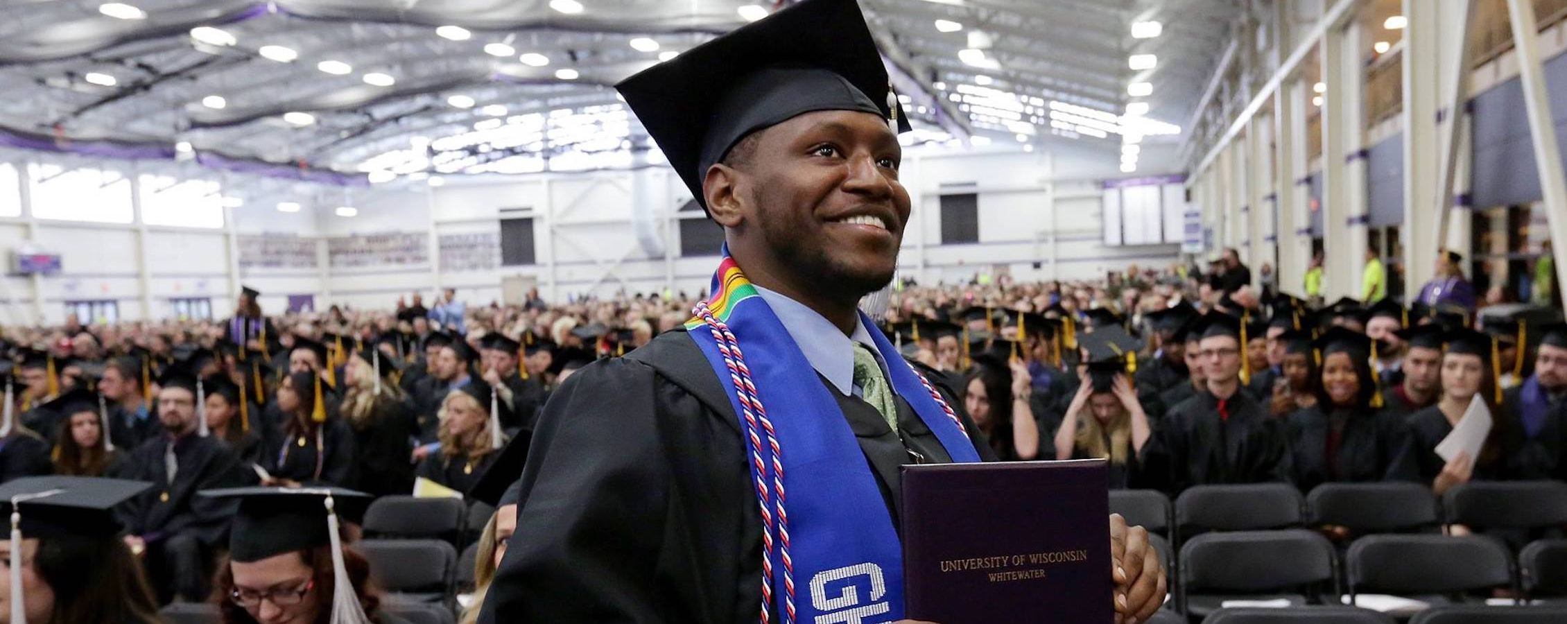 A student holds his diploma at commencement.