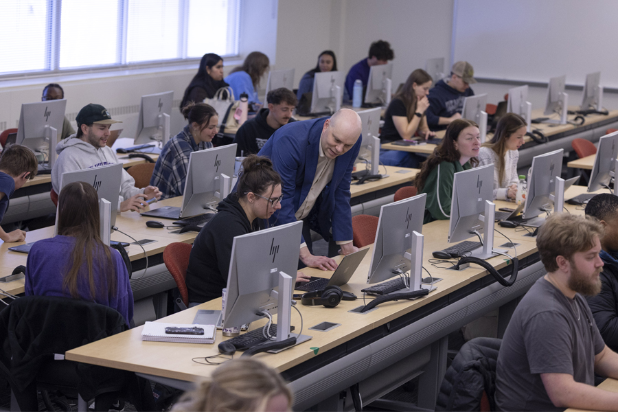 Students work on desktop computers in a classroom.