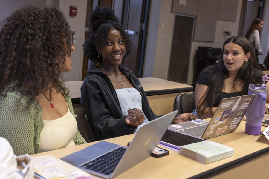 Three students talk together.