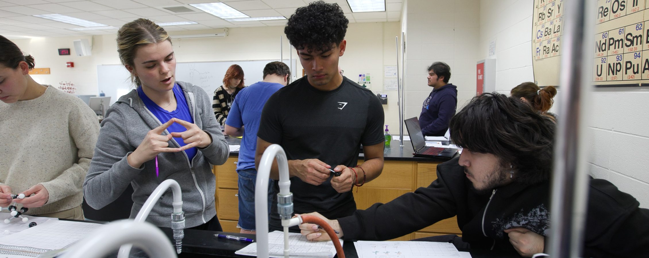 Two students work with a faculty member in a lab.