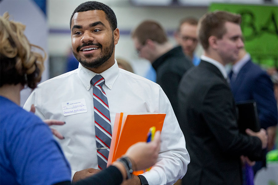 Business student talks to a professor on the University of Wisconsin Whitewater campus.