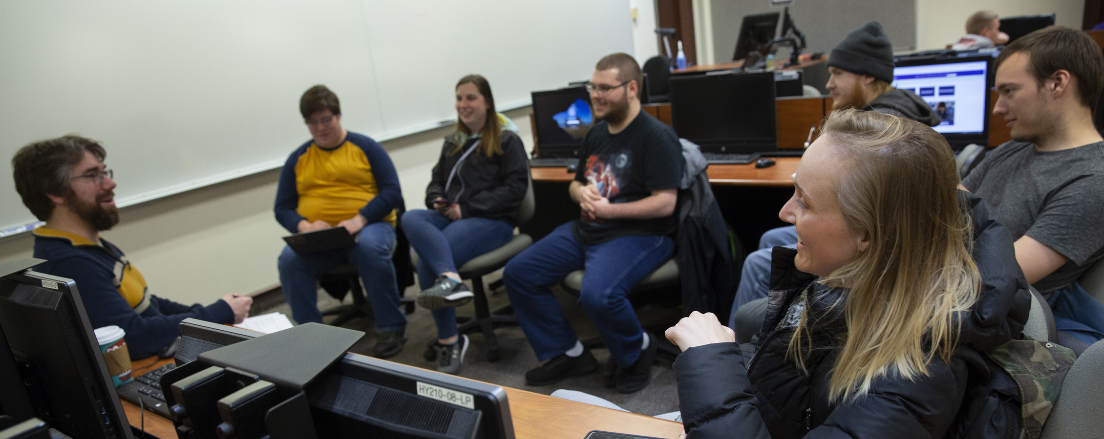 Students gather with a faculty member at a table.