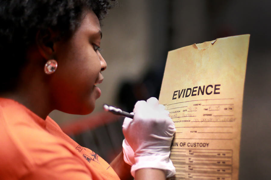 A student writes on an envelope marked "evidence".