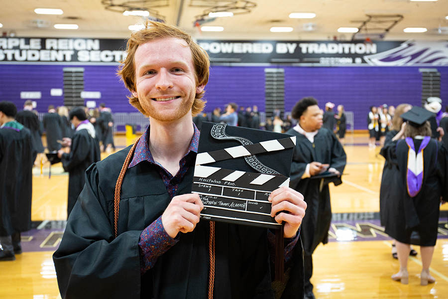 Matthew Albrecht at graduation shows his cap decorated like a clapperboard.