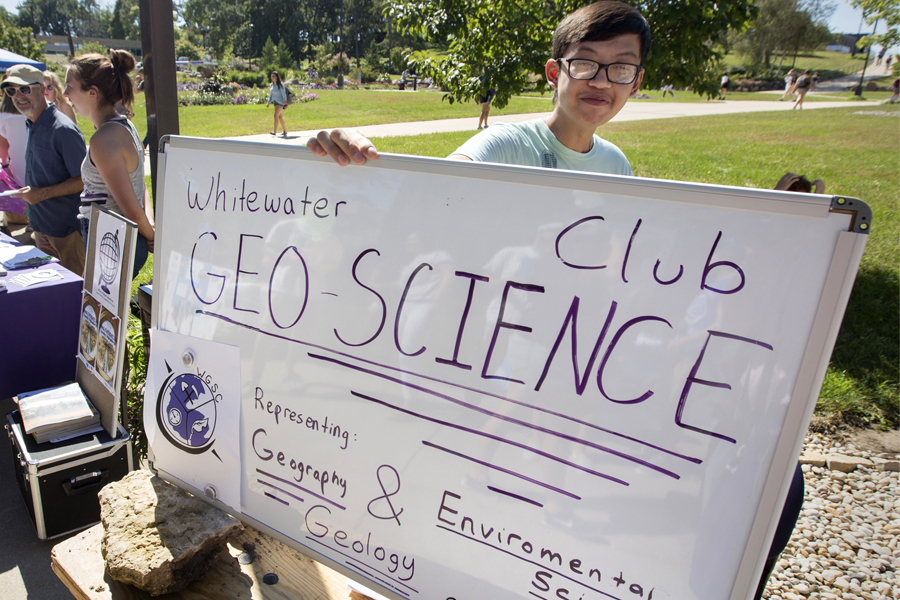 A student holds a sign that says Geo Science Club during the Involvement Fair.