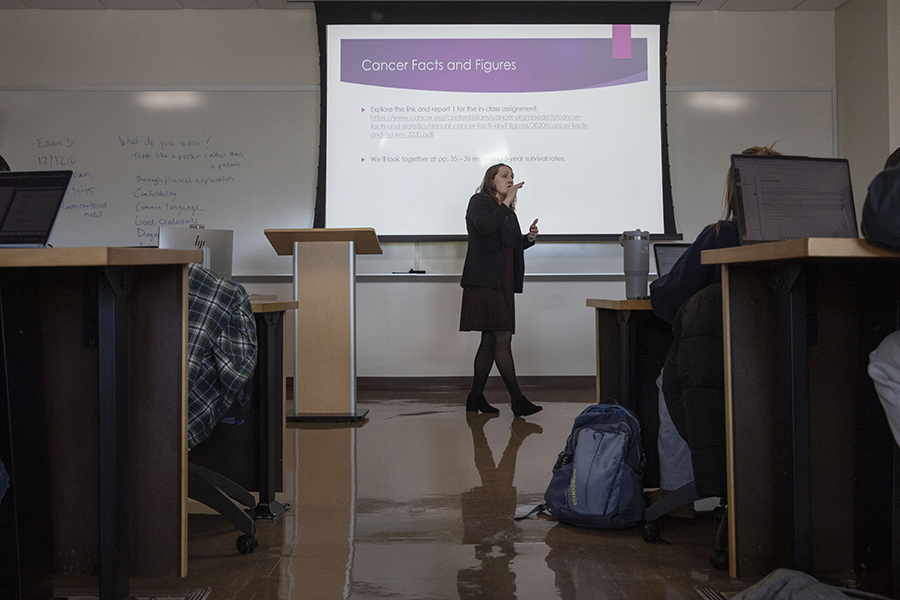 A faculty member teaches at the front of a classroom.
