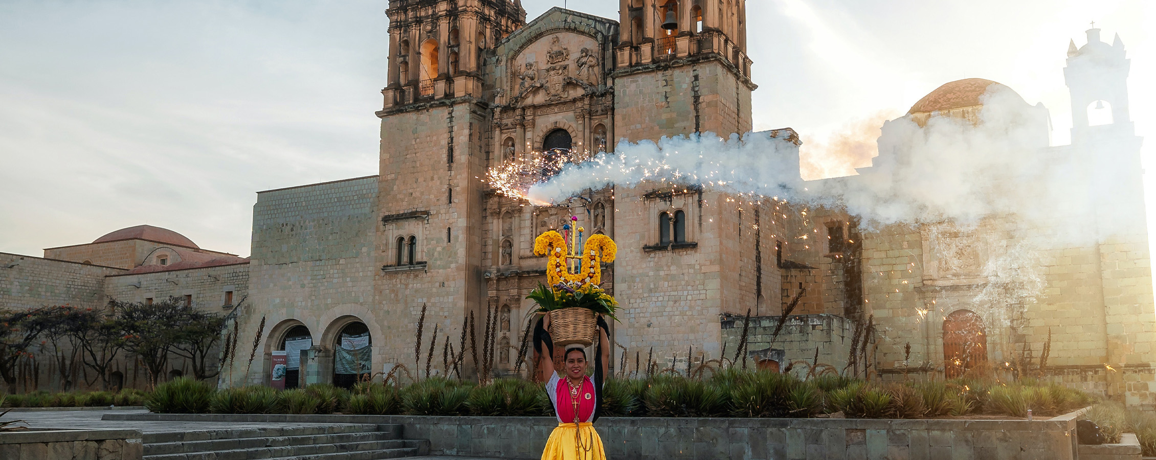 A person stands in front of a church in Mexico.