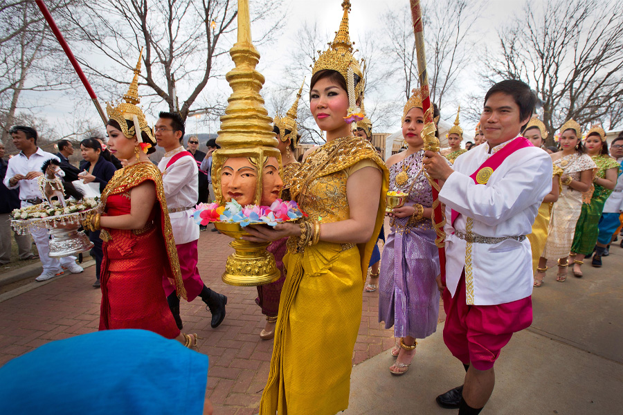 A woman dressed in gold is part of a procession during during Khmer New Year celebration in Southeast Asia.